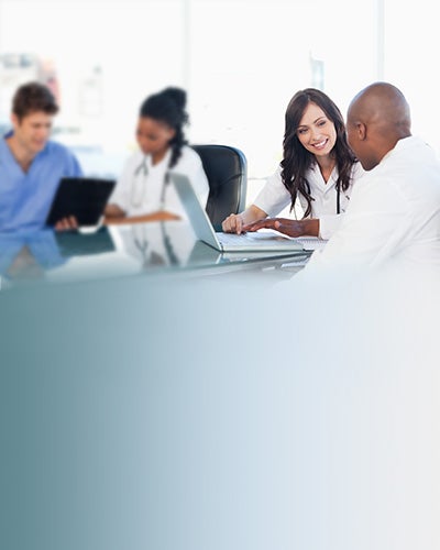 Medical team working on both a laptop and a clipboard