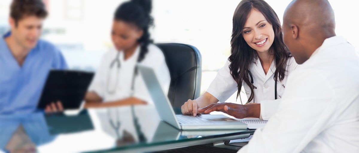 Medical team working on both a laptop and a clipboard